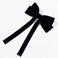 Detalle de un elegante lazo para el pelo en terciopelo negro con cintas largas fluidas - Negro