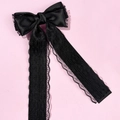 Detail einer eleganten schwarzen Schleife mit Spitze und Texturband auf rosa Grund - Schwarz