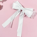 Detalle del lazo de pelo en satén blanco con bordes de encaje y cintas largas finas - Blanco