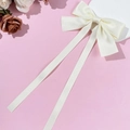 Detailansicht der cremefarbenen Satin-Schleife mit eleganten langen Bändern auf rosa Grund - Beige