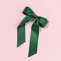Close-up of forest green forest satin ribbon bow hair clip on a soft pink background - Christmas Green