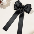 Detailansicht einer eleganten schwarzen Satin-Haarschleife mit langen fließenden Bändern - Schwarz