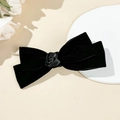 Elegant black velvet bow hair clip with a red satin rose on a minimalist display stand - Black