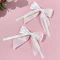 Detail van roze en witte zijden strik haarclips met zachte satijnen linten en natuurlijk licht - Roze