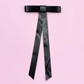Details der eleganten schwarzen Satin-Schleifen-Haarklammer mit langen Bändern auf Rosa - Federclips / Schwarz