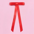 Eleganter roter Satin-Haarclip mit langen Bändern auf weichem rosa Hintergrund - Federclips / Rot
