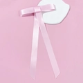 Detail der rosa Satin-Schleifen-Haarklammer mit langen Bändern auf elegantem Hintergrund - Federclips / Rosa
