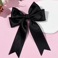 Detalle del elegante lazo de satén negro con borde de encaje sobre superficie rosa - Negro
