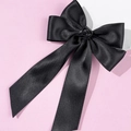 Makroaufnahme der eleganten schwarzen Satin-Haarschleife mit zentraler Rose - Schwarz