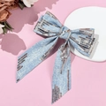 Detailed view of denim bow hair clip with bronze sequins on a soft pink background - Style 4 (Spring Clip)