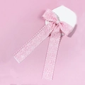 Detail einer rosa Spitzen-Haarschleife mit eleganten Bändern auf einem Steinständer - Rosa