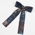 Detailed view of dark blue denim bow hair clip with rose gold sequins and long ribbons - Style 5 (Duckbill Clip)
