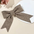 Close-up of knitted bow hair clip showing elegant oatmeal fabric texture and ribbon details - Khaki