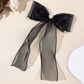 Detail of black tulle bow hair clip with pearls and rhinestones on a warm beige backdrop - Black