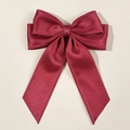 Detailaufnahme der burgunderroten Satin-Haarschleife mit elegant gewellten Kanten - Burgunderrot