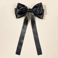 Detail showing the elegant black satin bow hairclip with long flowing streamers - Black