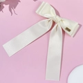Detalle de pinza de lazo en satén blanco crema con hebilla dorada y cintas muy largas - Beige