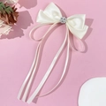 Nahaufnahme der cremefarbenen Satin-Schleife mit Perlen- und Strassblüten-Mittelstück - Beige