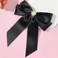 Elegant black satin bow hair clip with vintage pearl and rhinestone centerpiece on a pink background - Black