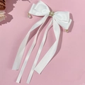 Details der weißen Satin-Haarschleife mit Perleneinlage und langen Bändern - Weiß