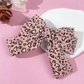 Dettaglio di un fermaglio per capelli con fiocco in tessuto leopardato rosa a cuori - Rosa