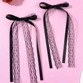 Detail einer schwarzen Schleife Haarspange mit Spitze und Bändern auf rosa Hintergrund - Schwarz