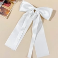 Detail of elegant white satin bow hair clip with long flowing ribbons and silky texture - White