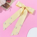 Detalle del lazo de satén amarillo claro con perlas y textura sedosa muy elegante - Amarillo