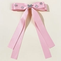 Detailed close-up of pink satin bow hair clip with rhinestone butterfly and stars decoration - Pink