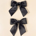 Detailansicht von zwei schwarzen Satin-Schleifen-Haarspangen mit seidigem Glanz - Schwarz