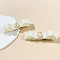 Dettaglio dei fermagli per capelli a fiocco in raso bianco a tre strati con perla centrale - Beige