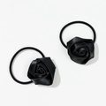 Close-up of two elegant black satin rose hair ties with elastic bands on white background - Black