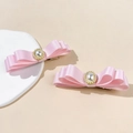 Dettaglio dei fermagli per capelli in raso rosa con perle centrali e finiture dorate - Rosa