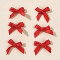 Set of 6 glossy red satin ballet bow hair clips neatly arranged on a beige background - Red