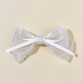 Détail de barrette nœud en tulle blanc avec rubans de soie et paillettes brillantes - Blanc