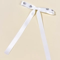 Detail einer weißen Satin-Schleifen-Haarspange mit silbernen Stern-Strass-Verzierungen - Weiß
