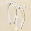 Detail einer weißen Satin-Schleife mit einem funkelnden Strass-Herz-Anhänger - Weiß