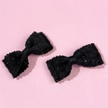 Détail de pinces à cheveux en tweed noir avec paillettes argentées et bords festonnés - Noir