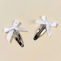 Detail shot of a pair of sweet white satin ribbon bow hair clips with silver metal BB clips - White