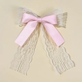 Dettaglio di un fermaglio per capelli in nastro di raso rosa con pizzo bianco e nastri - Rosa