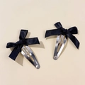 Close-up of two black satin ribbon bow hair clips with silver metal BB snap fasteners - Black