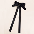 Detail einer eleganten schwarzen Satin-Haarschleife mit langen fließenden Bändern - Schwarz