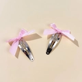 Detail shot of a pair of sweet pink ribbon bow hair clips with silver metal BB grip - Pink