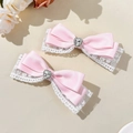 Dettaglio di fermagli per capelli con fiocchi di raso rosa, pizzo bianco e strass - Un paio / Rosa