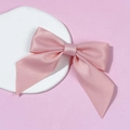 Pink satin bow accessory with smooth silk texture on white stone decorative prop - Pink