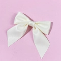 Detail of cream white satin bow tie with delicate woven texture on pink background - Beige