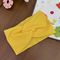 Close-up of bright yellow elastic knot headband on a rustic wooden surface background - Yellow