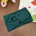 Detail of a dark green elastic cross-knot baby headband on a rustic wooden background - Dark Green