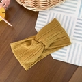 Detail shot of mustard yellow cable knit baby headband with twist knot on wood - Yellow