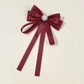 Detailed view of a wine red satin bow brooch with an elegant pearl and rhinestone center - Burgundy